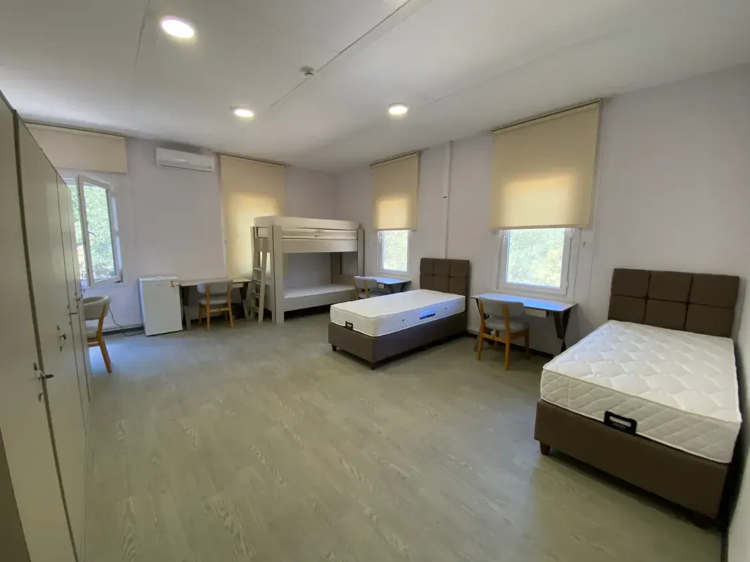 Spacious and well-lit bedroom containing single and bunk beds