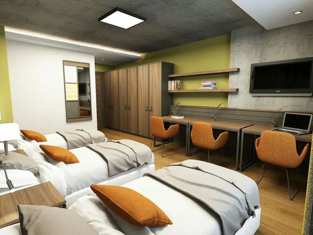 Female student double room with orange pillows and TV