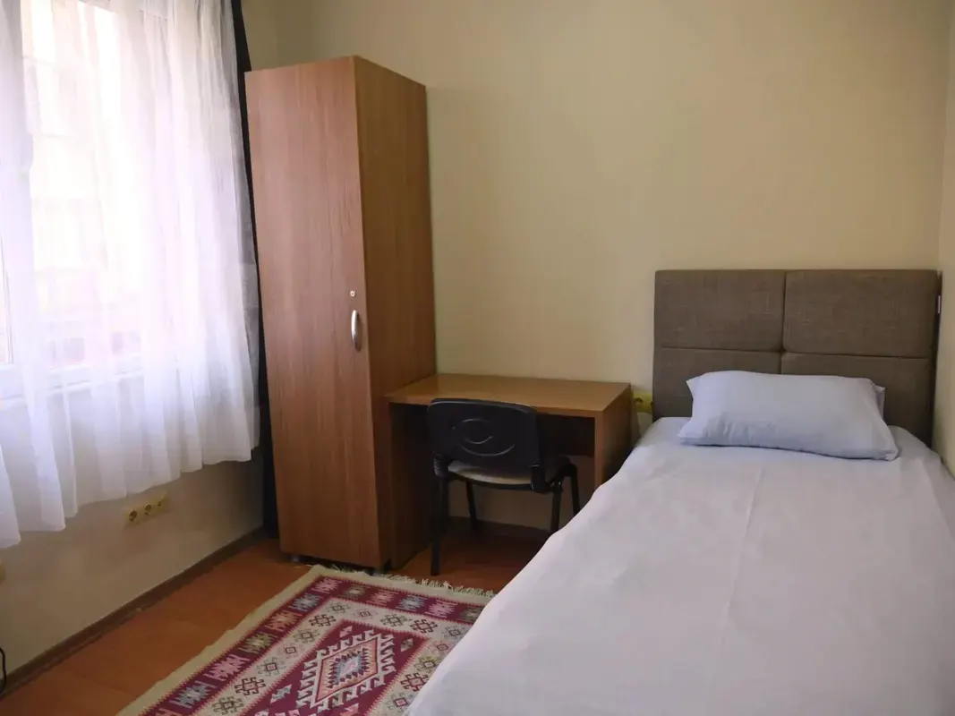 Room dedicated for one person containing a bed and study desk in Fatih residence